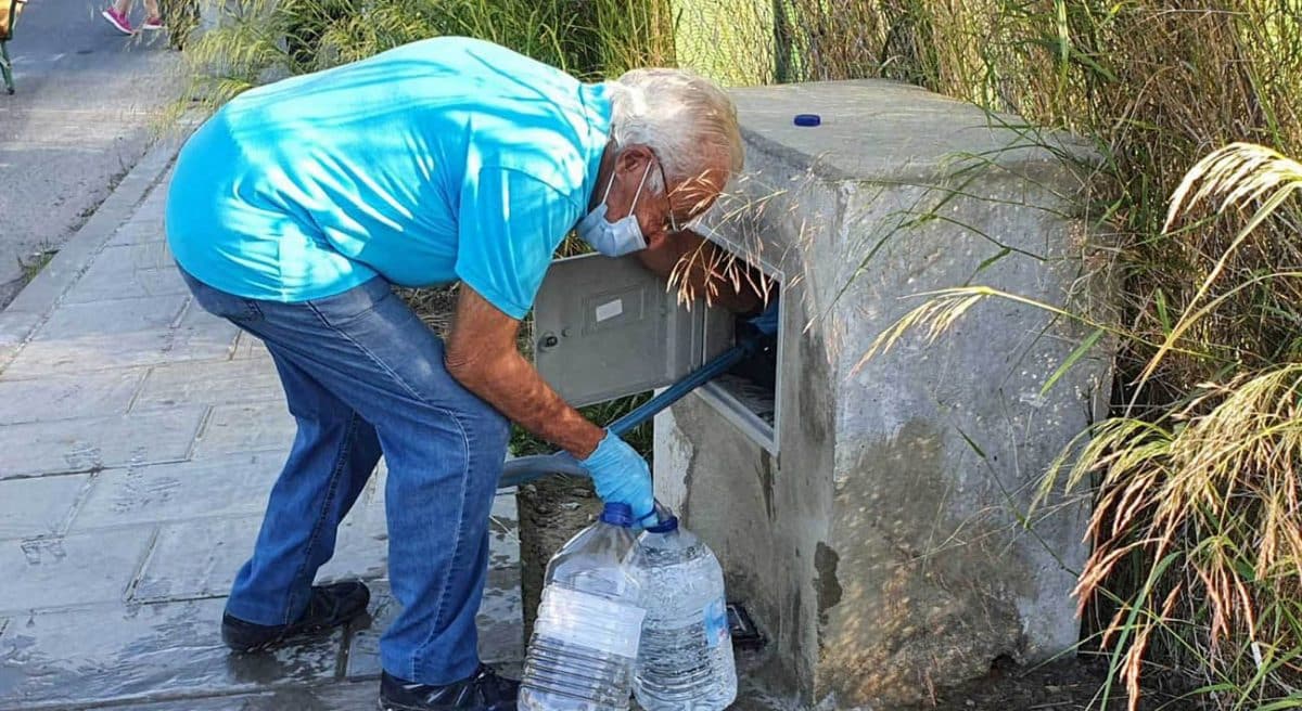 Un vecino del sector F de Almensilla recoge agua en el único grifo disponible