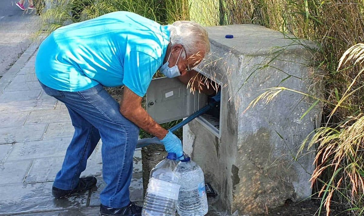 Un vecino del sector F de Almensilla recoge agua en el único grifo disponible