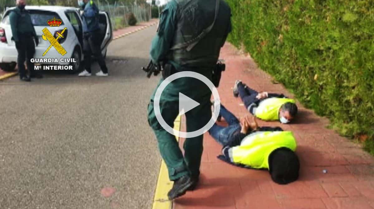 Dos de los detenidos, esposados en el suelo frente a la casa de Palomares.