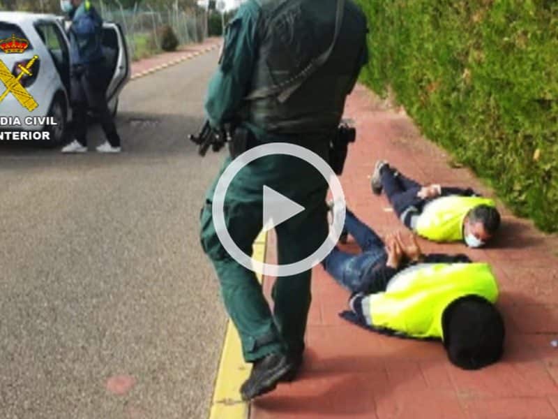 Dos de los detenidos, esposados en el suelo frente a la casa de Palomares.