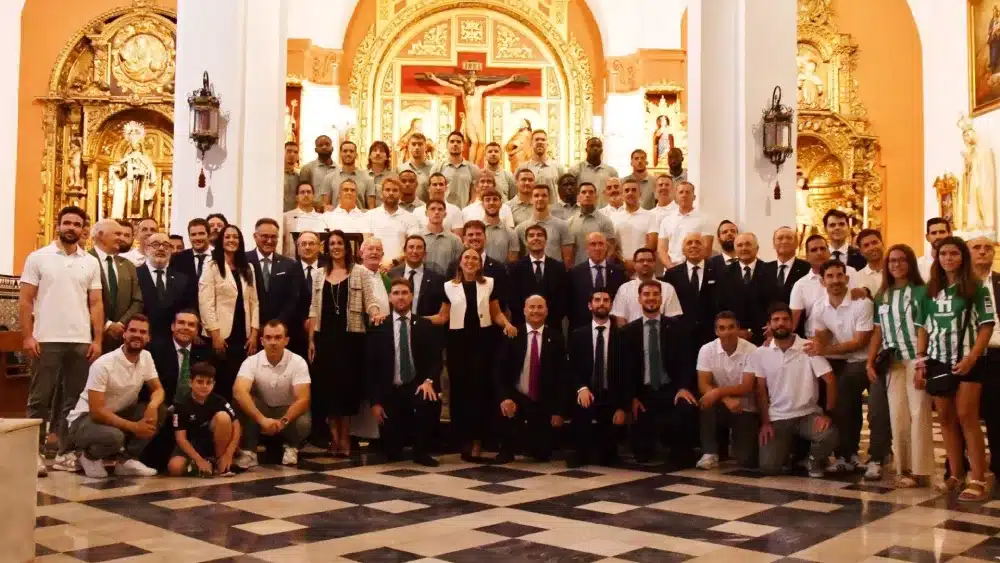 Dirigentes y cuerpo técnico del Real Betis en la tradicional ofrenda floral de inicio de temporada, en esta ocasión en la parroquia de Belén de Tomares. - AYTO.DE TOMARES